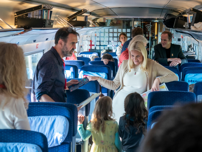 Kronprinsessen og illustratøren Svein Nyhus i samtale med barn på toget. Foto: Heiko Junge, NTB scanpix